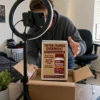 An aspiring content creator films an unboxing of the TikTok Famous Overnight novelty product using a phone and ring light