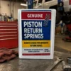 Piston Return Springs Mechanic Prank Piston Return Springs prank package displayed in a mechanic shop