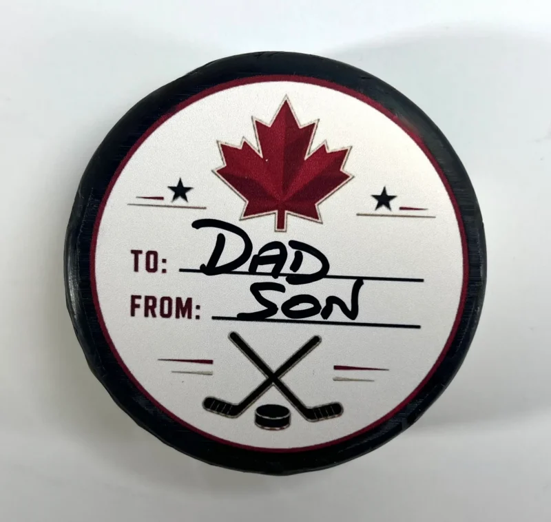 Top view of a personalized hockey puck gift with custom To and From label, perfect for birthdays, coaches, teammates, and hockey fans.