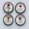 Four custom hockey puck designs on ice: To and From, Official Canadian Apology, Team MVP, and Best Chirper.
