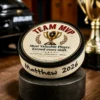 Team MVP hockey puck award with custom player name and year displayed beside championship trophies.
