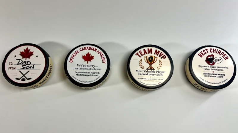 Collection of custom hockey pucks featuring personalized messages, awards, and funny hockey gift designs.
