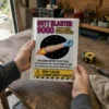Adult holding a Butt Blaster 9000 prank mailer in a home workshop