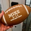 The Fumble personalized fantasy football held in hand showing its compact size