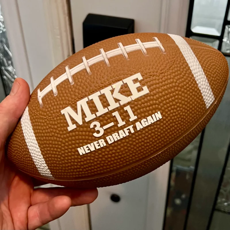 The Fumble personalized fantasy football held in hand showing its compact size