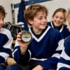 Young hockey player holding a personalized Happy Birthday hockey puck