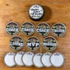 Hockey Coach Thank-You Stickers with Write-On Backs Black and gold thank-you stickers for hockey coaches and team helpers, with white write-on backs on a wooden table. A puck above shows “Thanks Coach!! The Wolves 2026/27” handwritten on its sticker.
