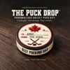 The Puck Drop Personalized Hockey Puck Gift Personalized hockey puck with a Canadian maple leaf, “To: Dad, From: The Kids” on top and “Best Pucking Dad” around the edge, displayed on dark wood.